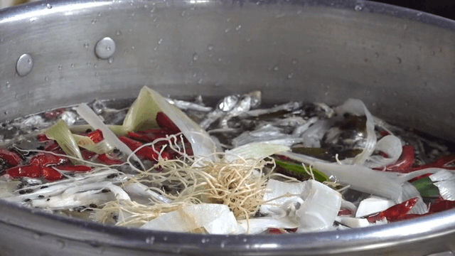 Various ingredients being added to a pot