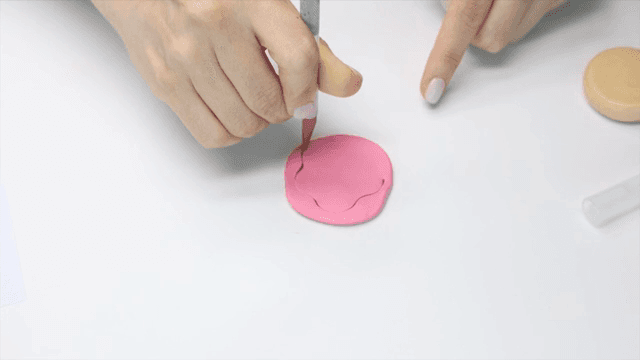 Hands crafting with pink clay