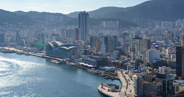 Paranomic view of a bustling port city with tall skyscrapers and bridge