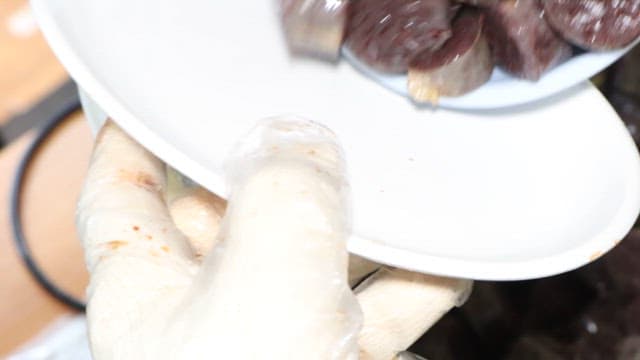 주방에서 갓 조리된 순대를 접시에 옮기는 모습