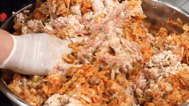 김치 만두 속 재료를 섞는 장면