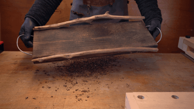 Person crafting with wooden tools indoors