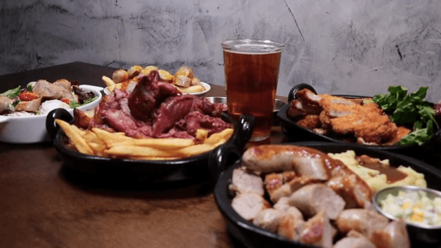 Table with various dishes and a glass of beer