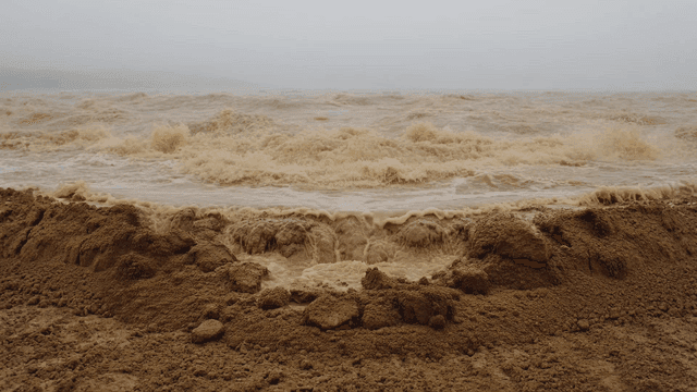 Waves crashing on a muddy shore