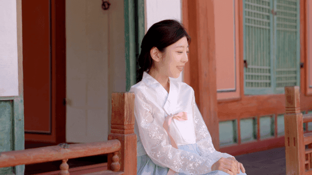 마루에 앉아 있는 한복 입은 여성