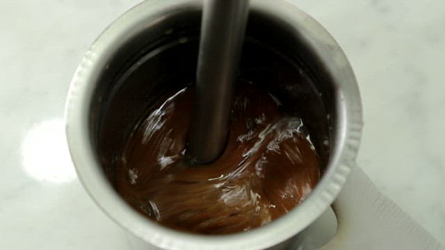 Blending sauce made with red bean in a metal container