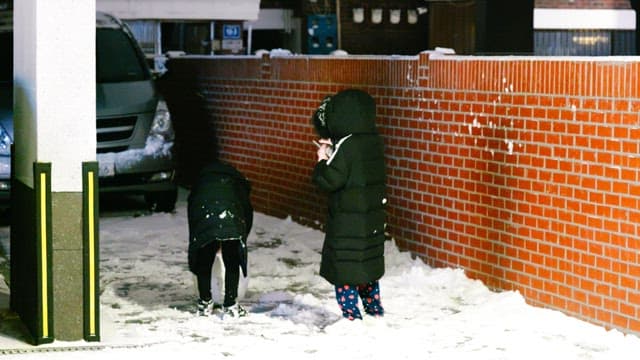 주택가 골목에 쌓여 있는 눈을 굴리며 노는 아이들