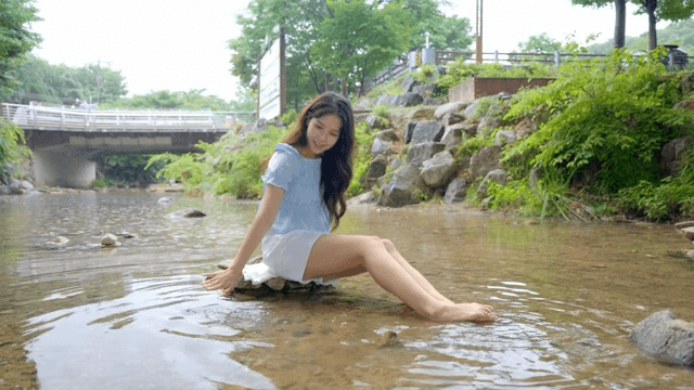 푸른 지역의 개울을 즐기는 여성