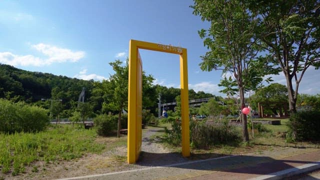 Outdoor park with a yellow frame and deer statues on a sunny day