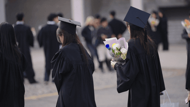 Graduates holding bouquets of flowers