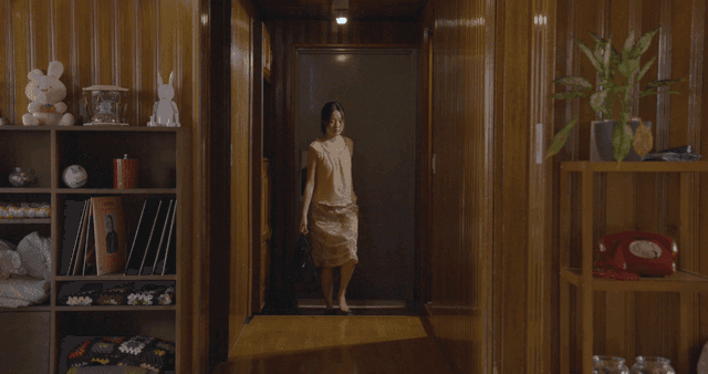 검은 봉지를 들고 집에 들어오는 여성