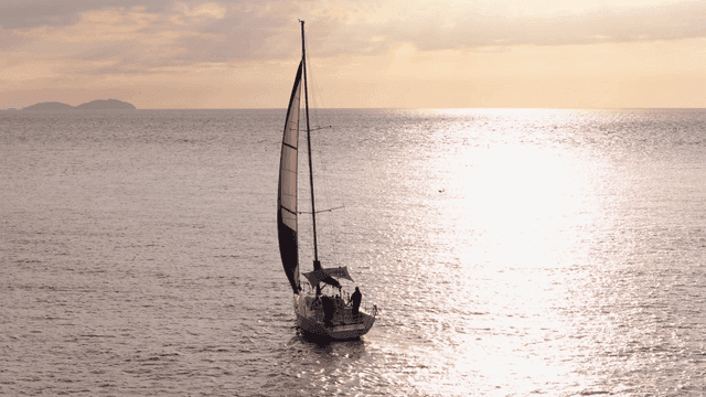 일몰에 잔잔한 바다를 항해하는 요트