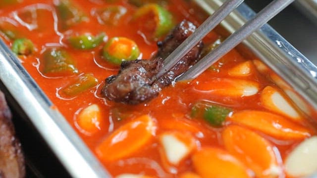 양념장에 찍어먹는 먹음직스러운 돼지 부속 구이 한 점