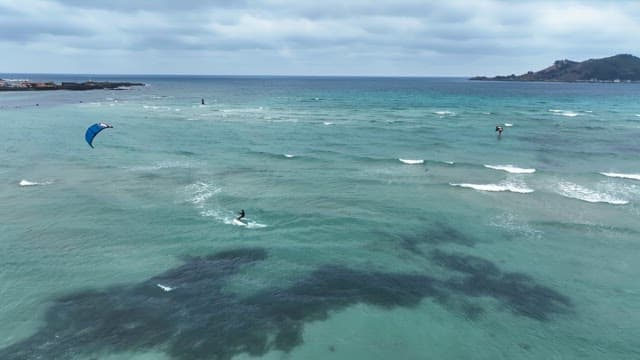 Kite surfers gliding over ocean waves