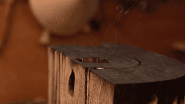 연기가 피어오르는 나무 조각품 윗 표면