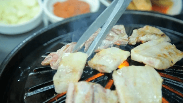 뜨거운 그릴 위에 생갈비 굽기