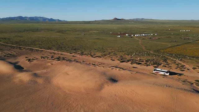 Vast desert landscape with a bus