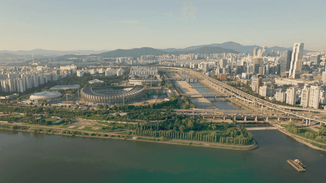 A sprawling cityscape with a stadium and river