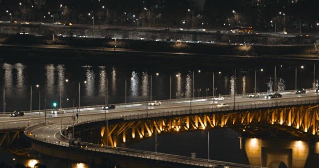 Illuminated bridge over river at night