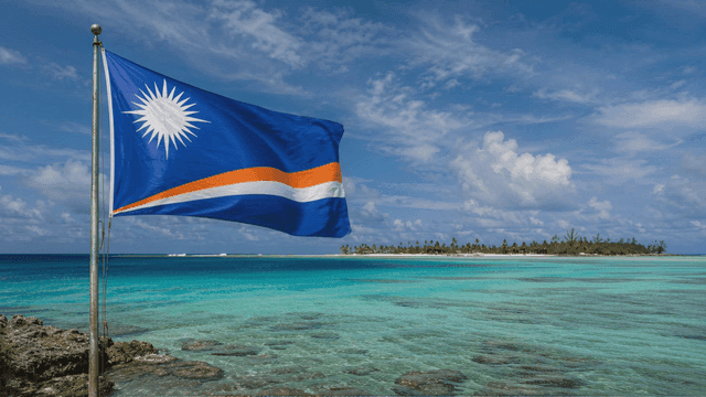 Marshall Islands flag fluttering on tropical beach