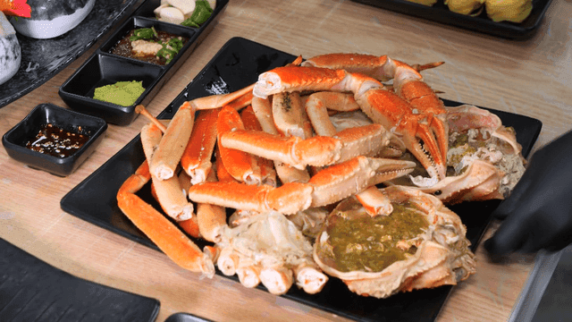 Plate containing fresh steamed snow crab and side dishes