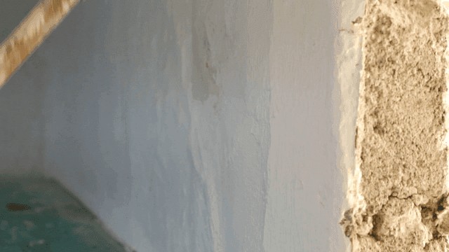 롤러 브러시로 벽을 칠하는 모습