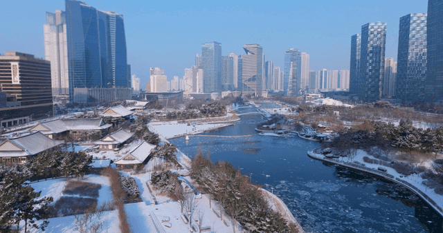 Snow-covered traditional Hanok buildings and modern high-rise buildings