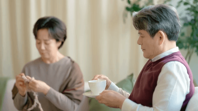 Elderly couple enjoying tea and knitting