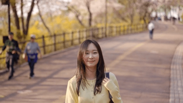 Woman walking on a sunny park path