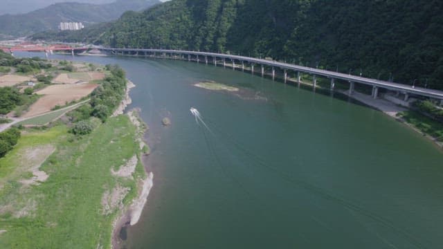 Speedboat Cruising Down Serene River Beside Bridge