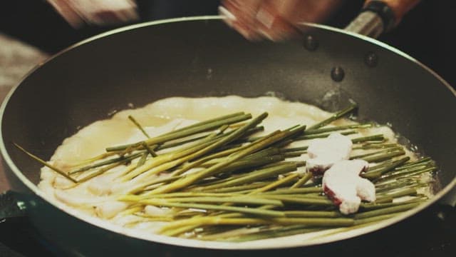 Korean pancakes made with chives and mushrooms in a frying pan