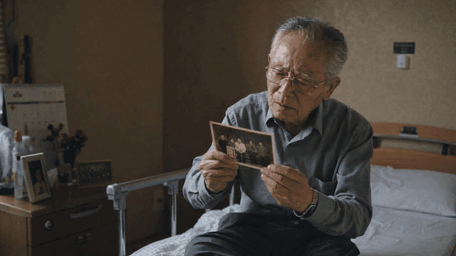 Old man looking at old photograph