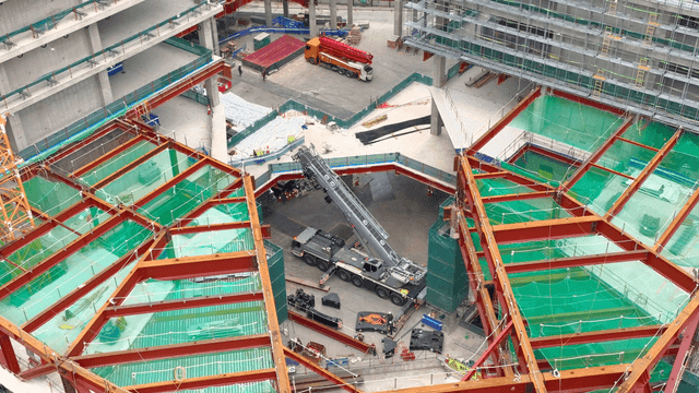 Large construction site with cranes and steel beams