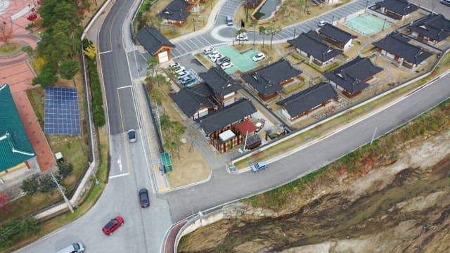 주차장으로 들어오는 차들이 보이는 전통 한옥마을