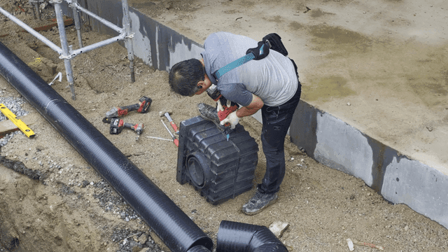 건설 현장에서 전동 공구를 사용하는 작업자