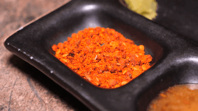 Red seasoning powder on black plate