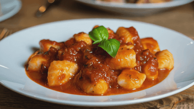 Gnocchi in rich tomato sauce garnished with basil