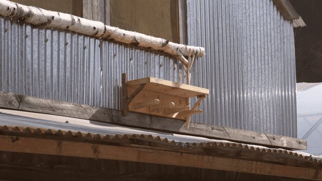 금속 헛간 벽에 있는 나무 거치대 선반