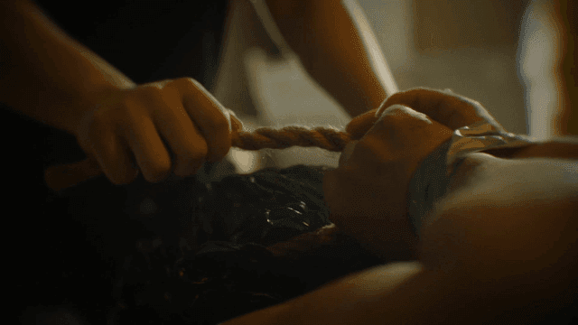 Person holding rope that ties his hands