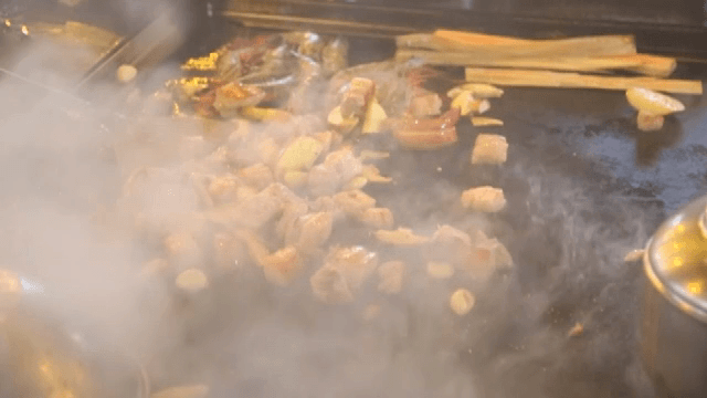 Various ingredients sizzling on a grill