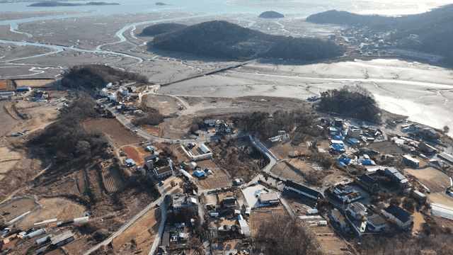 Aerial view of a coastal village and mudflats