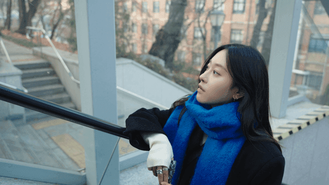 Woman in a blue scarf standing on an escalator