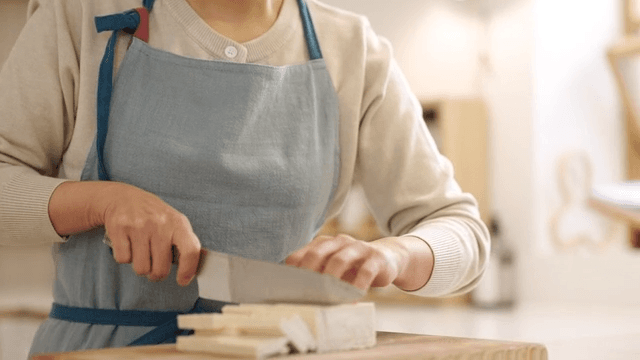 Woman cutting tofu in cozy kitchen