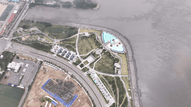 Aerial view of construction site next to road and park