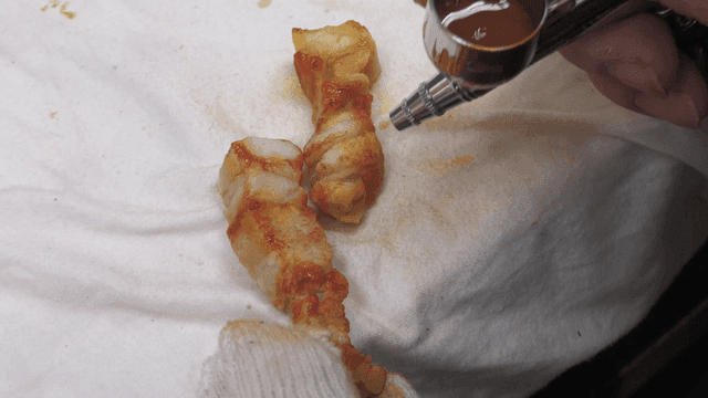 Craftsman using airbrush to paint pork belly model