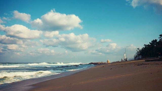 푸른 하늘 아래 잔잔한 파도와 아늑한 해변