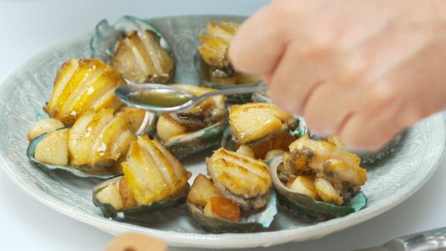 Appetizing butter-grilled abalone plated on a plate