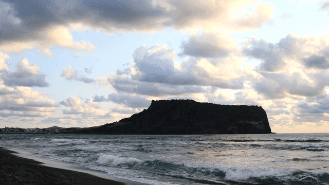 Quiet beach with island visible in distance.