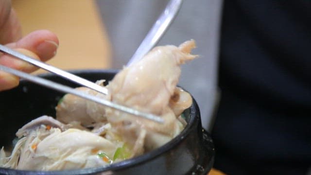 Using chopsticks to dip chicken in salt