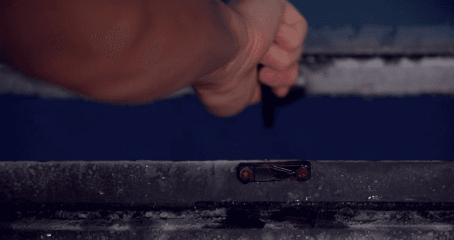 서리가 낀 창문의 걸쇠를 열고 닫는 손